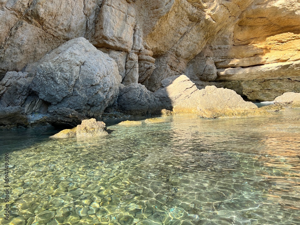 Rocky coast by Mediterranean sea with clear water and smooth stones pebbles at the bottom. Rocky coast by Mediterranean sea with clear water and smooth stones pebbles at the bottom.
