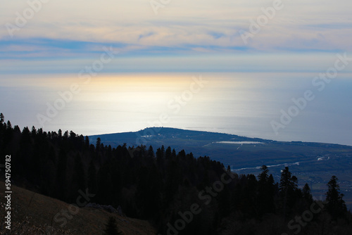 Sunrise in the mountains view from the hill to the misty valley and the sea with the sky on the horizon
