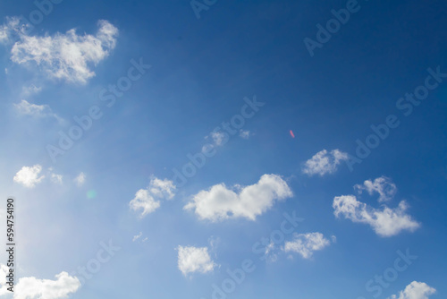 White airy beautiful clouds in a bright blue sky. Clear sunny weather. The concept of environmental safety and cleanliness.