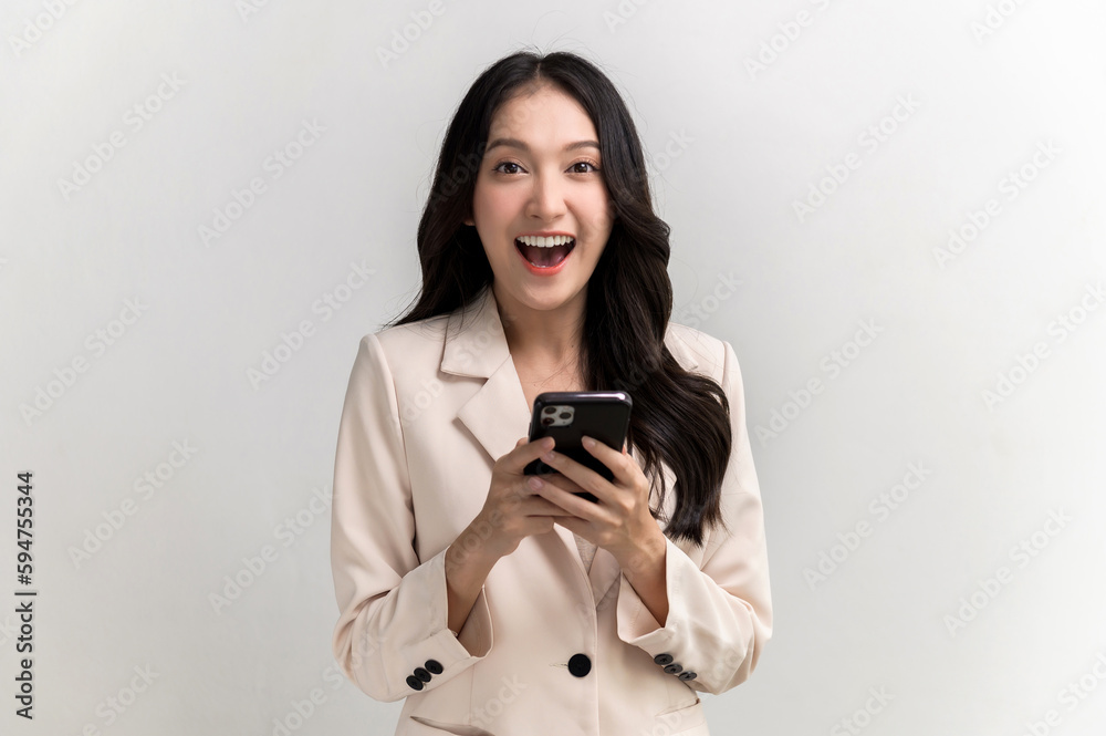Portrait photo of young beautiful Asian woman feeling happy or surprise shock and holding smart phone on white background can use for advertising or product presenting concept. Portrait photo of young beautiful Asian woman feeling happy or surprise shock and holding smart phone on white background can use for advertising or product presenting concept.