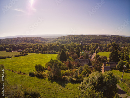 Drone photo of houses between trees and mountains in Belgium  beautiful horizon view
