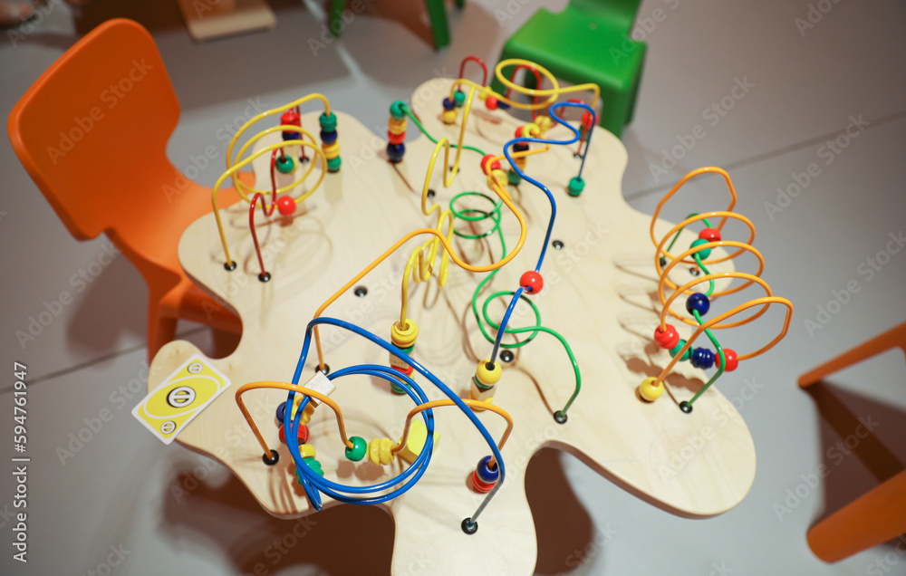 classic beads maze toy featuring colorful beads on wires, which kids can move around. Symbolizes early childhood development of motor skills and hand-eye coordination, as well as the concept of cause 
