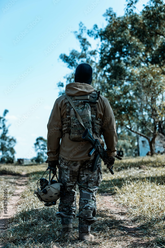 Anonymous soldier with AK-47 in the middle of the battlefield