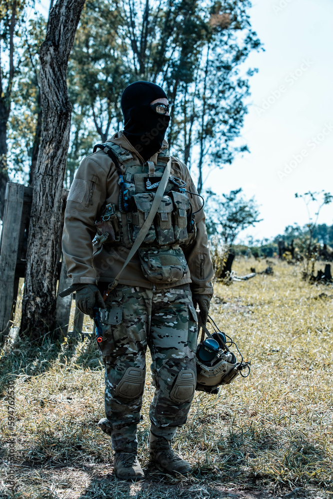 Fototapeta premium Anonymous soldier with AK-47 in the middle of the battlefield