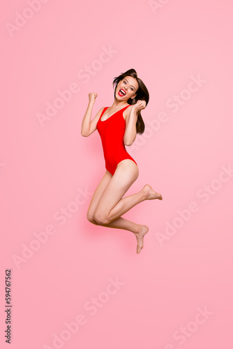 Finally, holidays Full-legs vertical portrait of girl jumping clenching her hands in fists and joyfully screaming isolated on yellow background