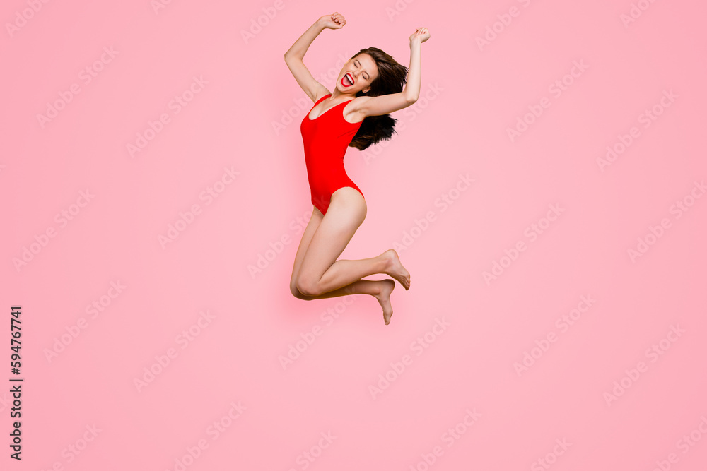 Finally, summer Full-body portrait of crazy brunett girl in red body with closed eyes jumping clenching her hands in fists and joyfully screaming isolated on yellow background Finally, summer Full-body portrait of crazy brunett girl in red body with closed eyes jumping clenching her hands in fists and joyfully screaming isolated on yellow background