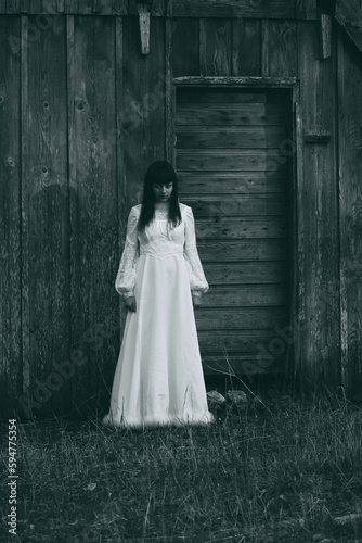 Horror scene of woman in white dress. Bluish vintage look