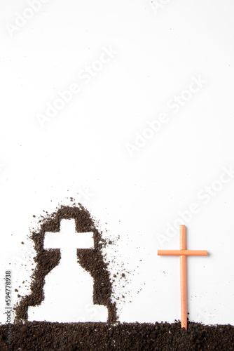 top view of cross shape with dark soil on white surface grim reaper funeral
