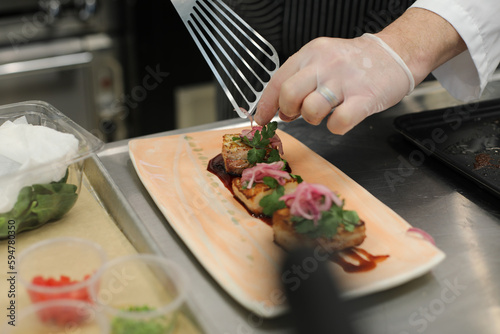 Chef Plating Sous Vide Red Wine Braised Pork Shoulder in Commercial Kitchen 