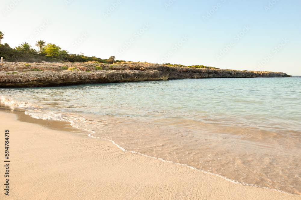 Beautiful tropical beach shoreline with ocean waves lapping at the sand on the sea shore at a tourist vacation destination