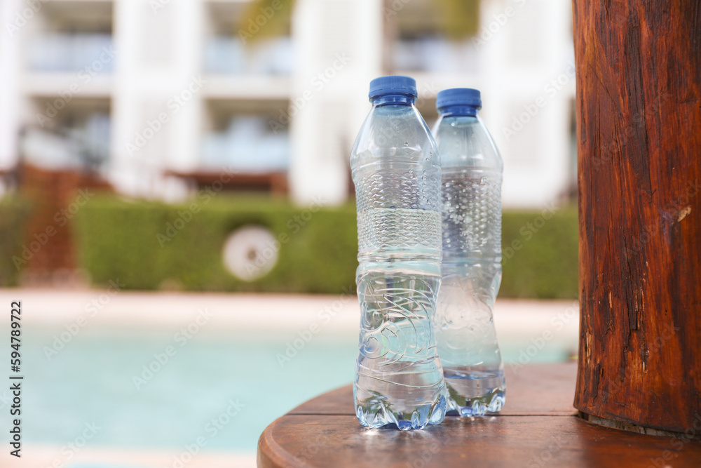 plastic bottles scattered around the pool and beach represent the negative impact of human activity on the environment. The pollution caused by single-use plastic bottles affects the ocean plastic bottles scattered around the pool and beach represent the negative impact of human activity on the environment. The pollution caused by single-use plastic bottles affects the ocean
