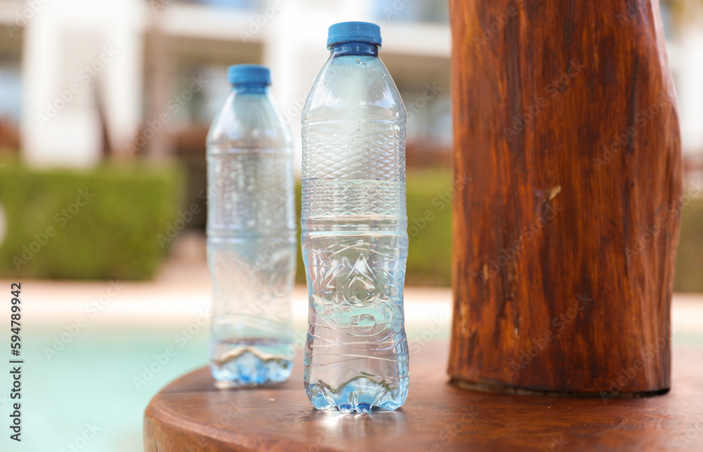 plastic bottles scattered around the pool and beach represent the