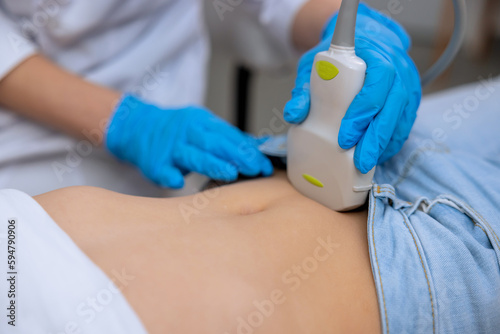 Doctor performing ultrasound scan on little girl medical specialist examining child abdominal cavity