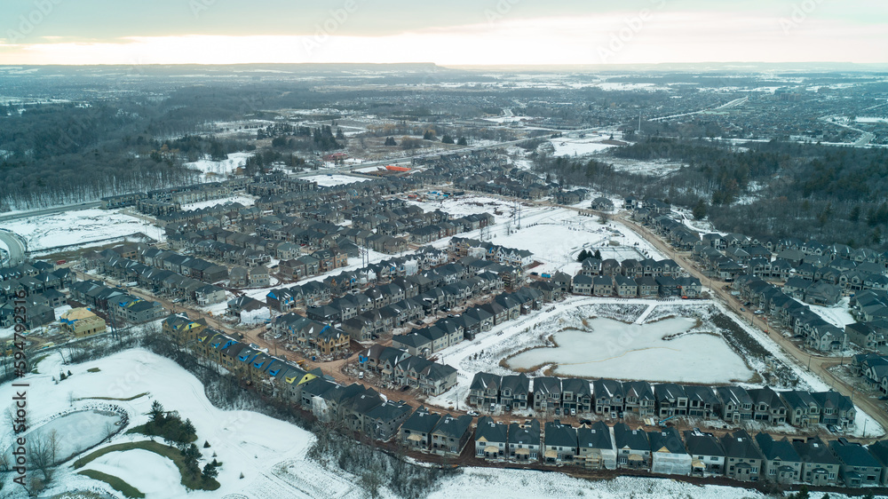 An aerial shot of new houses being built in the suburbs during the winter