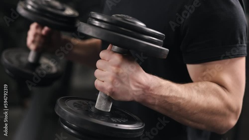 Sportsman strength, Weight training, Body conditioning. Strong man participates in functional training with dumbbells, diligently performing various exercises to improve overall fitness build toned photo