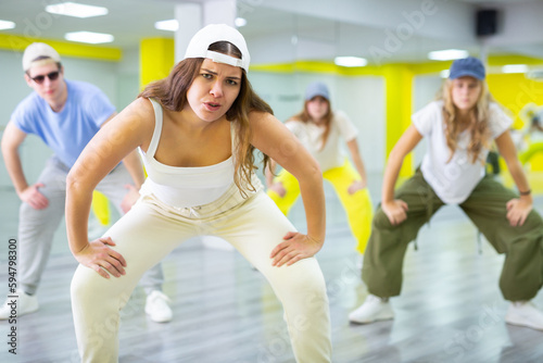 Young girl in cap dancing hip hop dances in dance studio photo