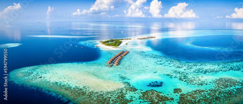 Fototapeta Naklejka Na Ścianę i Meble -  Panoramic aerial view of a turquoise coral reef and lagoon with a tropical paradise island and calm sea at the Maldives, Indian Ocean