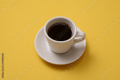 黄色いテーブルの上に置かれたホットコーヒー
