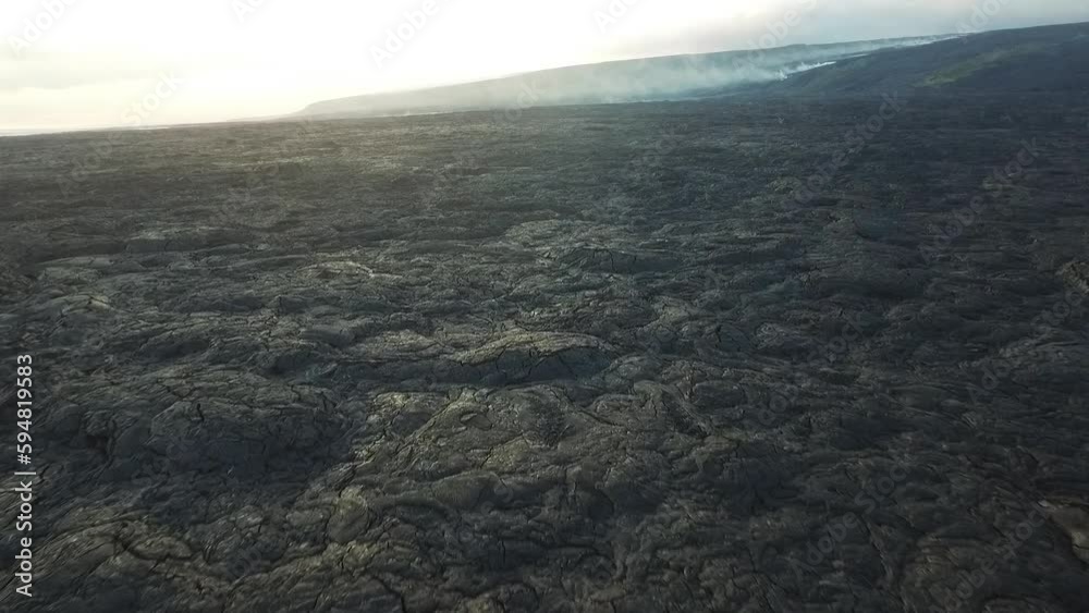 Hawaii lava field with smoking lava flow in the background aerial view Hawaii lava field with smoking lava flow in the background aerial view