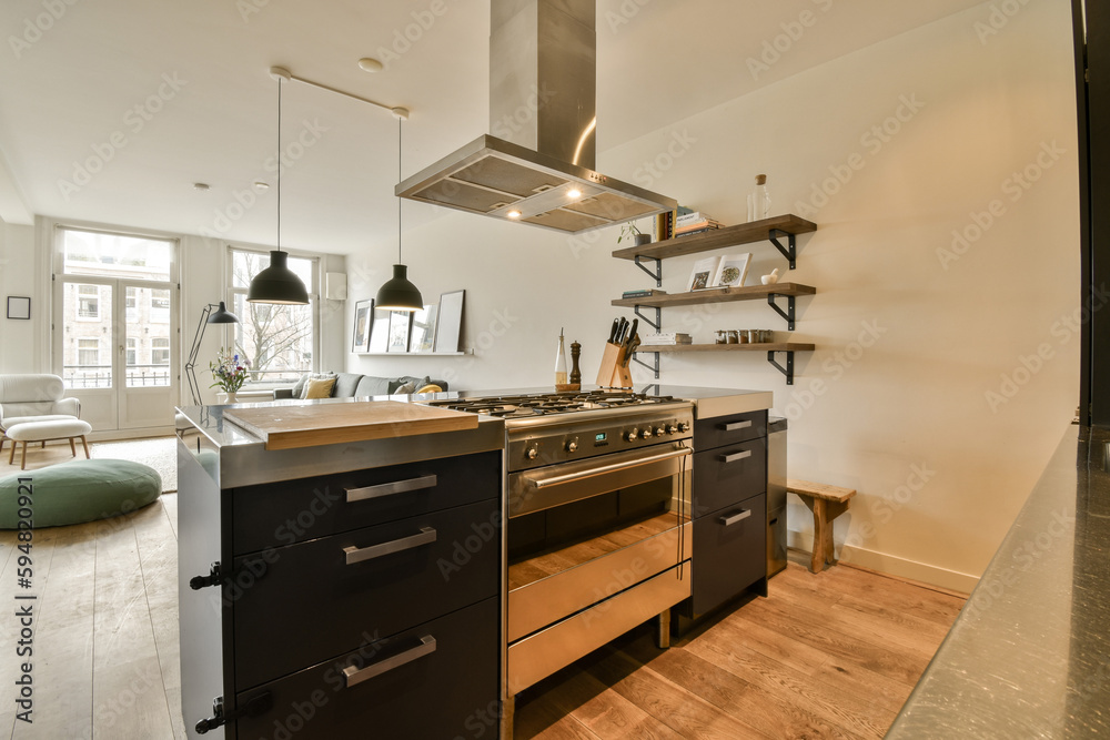 a modern kitchen with black cabinets and stainless steel range hoods on the wall above it is an open fireplace a modern kitchen with black cabinets and stainless steel range hoods on the wall above it is an open fireplace