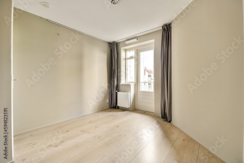an empty room with wood floor and beige curtains on the windowsilling, there is no one person in the room