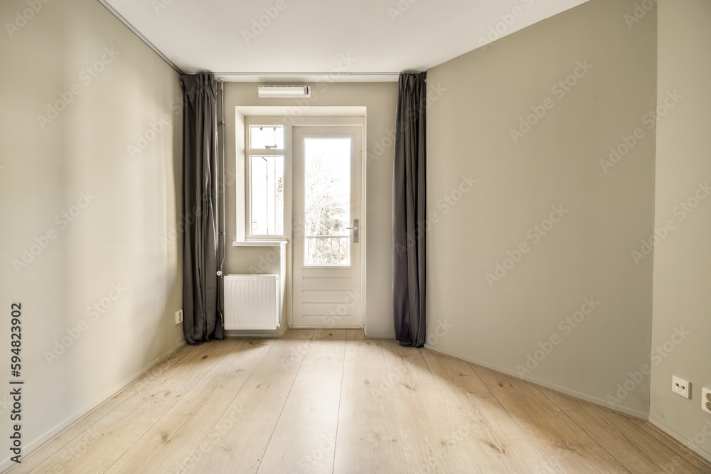 an empty room with wood flooring and curtains on the windowsills, in front of a white door an empty room with wood flooring and curtains on the windowsills, in front of a white door
