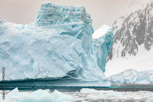 Beautiful Sculptural Turquoise Blue Iceberg on the Antarctic Peninsula With Bergy Bits Floating in the Sea