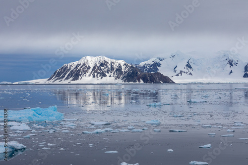 Steep Snowclad Mountains Reflected in Still Water in The Gullet, Adelaide Island, Antarctica Peninsula photo