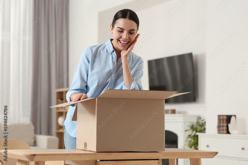 Emotional young woman with opened parcel at home. Internet shopping Emotional young woman with opened parcel at home. Internet shopping