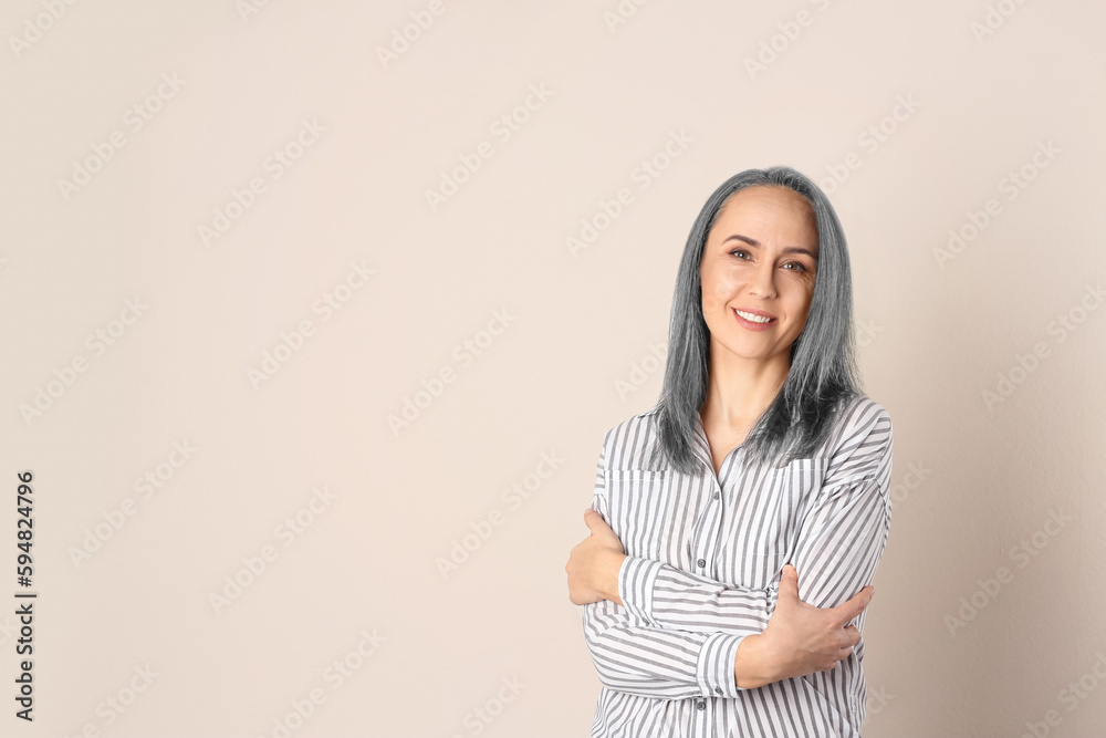 Fototapeta premium Portrait of smiling woman with ash hair color on beige background. Space for text