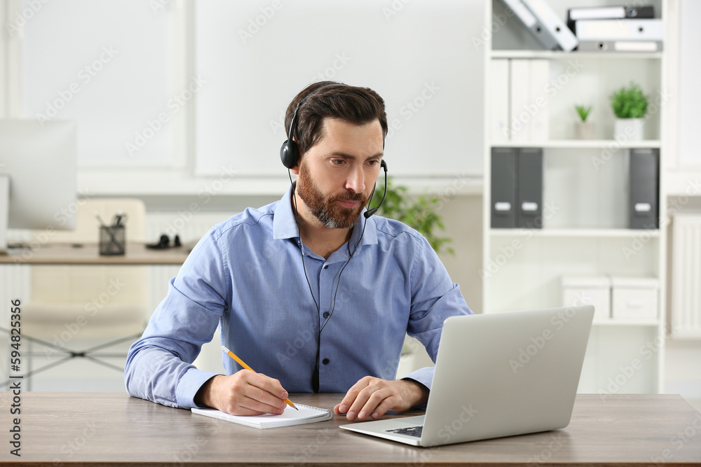 Fototapeta premium Hotline operator with headset working in office