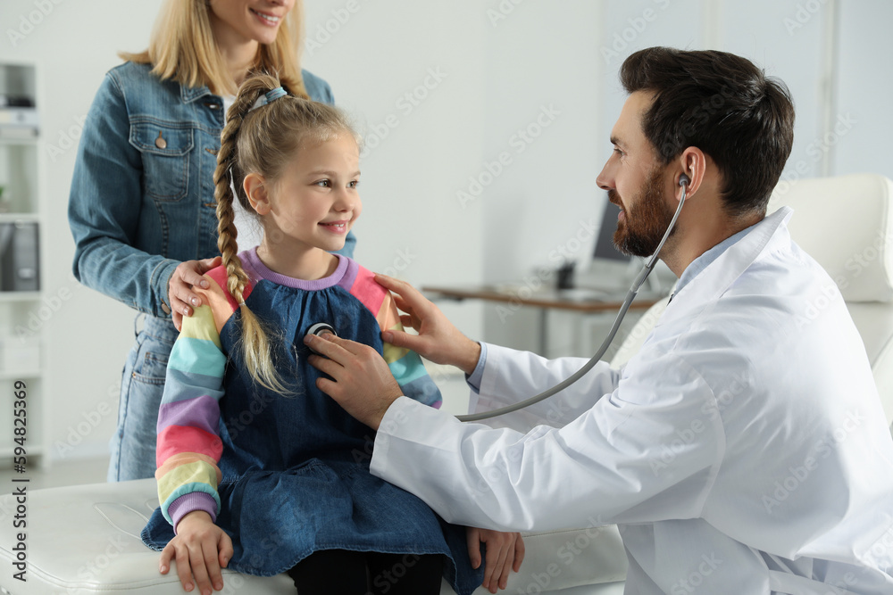 Obraz premium Mother and daughter having appointment with doctor. Pediatrician examining patient with stethoscope in clinic