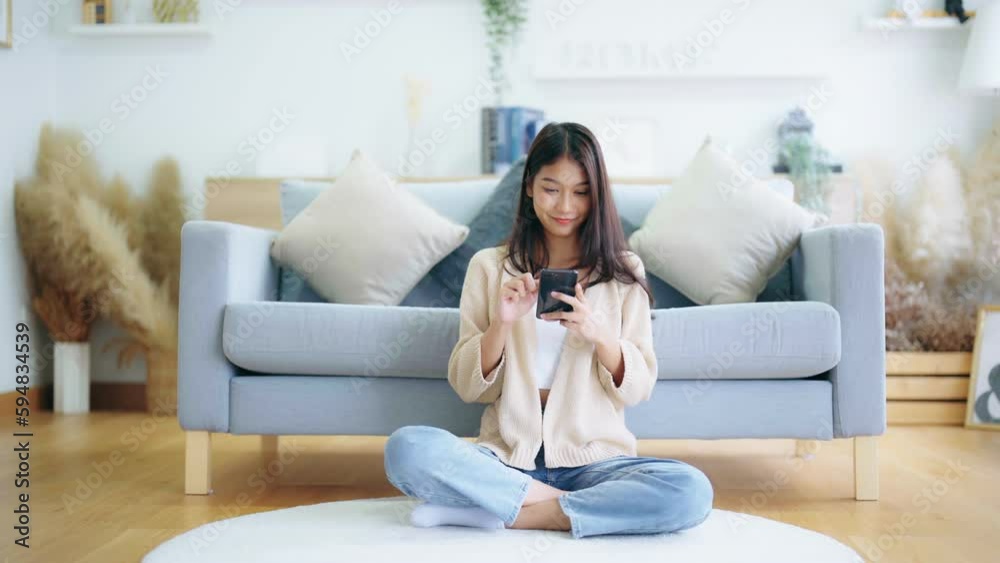 Happy young asian woman relax on comfortable couch at home texting messaging on smartphone, smiling girl use cellphone, chatting online message, shopping online from home Happy young asian woman relax on comfortable couch at home texting messaging on smartphone, smiling girl use cellphone, chatting online message, shopping online from home