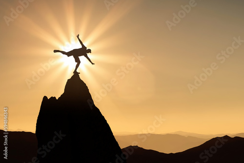 Silhouette of man at the sunset balancing on one leg