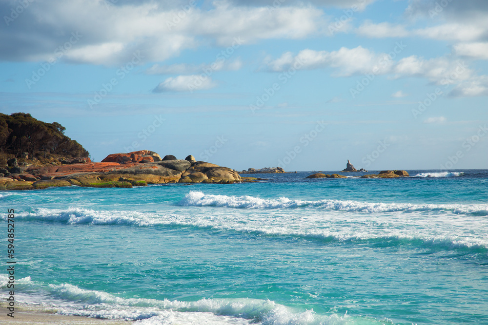 Naklejka premium Clear blue turquoise ocean, white sand beach and orange rocks at Bay of fire, a bay in Tasmania