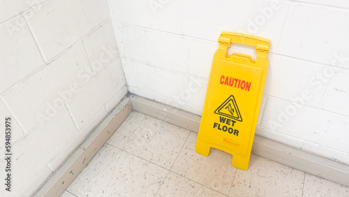A yellow wet floor sign is a symbol of caution and warning, indicating a slippery and potentially hazardous area. It represents safety, prevention, and the need for attention and alertness in public 