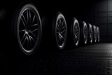 Black rubber tires standing in row line on dramatic dark background