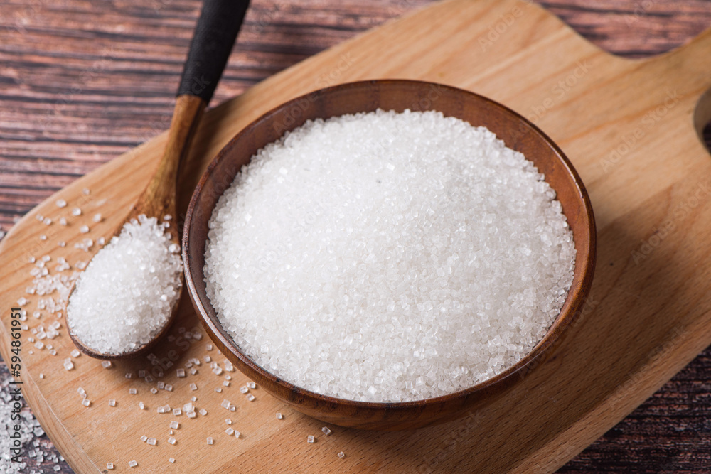Bowls and spoons are filled with sugar on a wooden background Bowls and spoons are filled with sugar on a wooden background