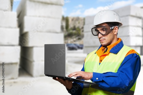 Portrait of smart engineer wearing safety helmet use laptop computer