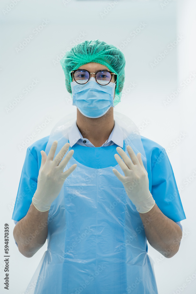 Man male obstetrician doctor portrait in uniform coat gown with white hand grove. Medical senior gynecologist stand by give birth wear blue gown coat stand in delivery room pregnant hospital. Man male obstetrician doctor portrait in uniform coat gown with white hand grove. Medical senior gynecologist stand by give birth wear blue gown coat stand in delivery room pregnant hospital.