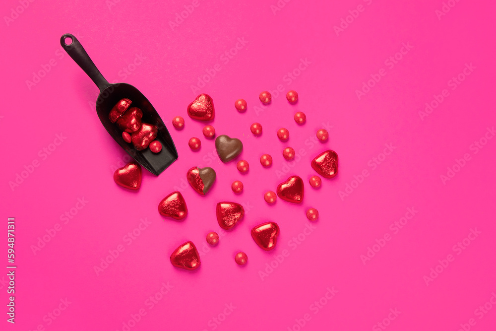 Wrapped and unwrapped heart shape chocolate candies in red foil on pink background Wrapped and unwrapped heart shape chocolate candies in red foil on pink background