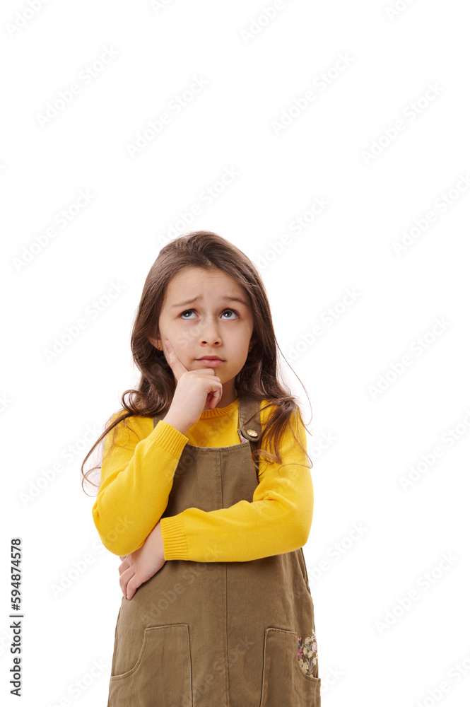 Thoughtful pensive little girl wearing casual khaki dress, holding chin, looking up, thinking about future and reasoning over problems, posing on white background with serious facial expression. Thoughtful pensive little girl wearing casual khaki dress, holding chin, looking up, thinking about future and reasoning over problems, posing on white background with serious facial expression.