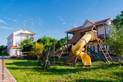 Children's playground on a wooden terrace near a country house or a summer hotel
