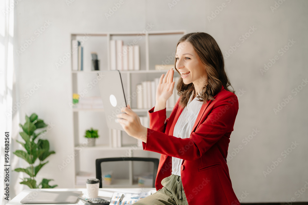 Working woman concept a female manager attending video conference and holding tablet, smatrphone and cup of coffee in office Working woman concept a female manager attending video conference and holding tablet, smatrphone and cup of coffee in office