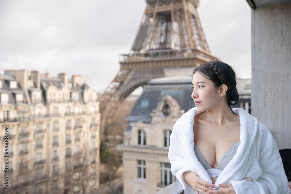 Fototapeta premium Sexy woman on balcony enjoying view at Eiffel Tower in Paris.