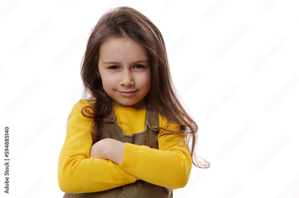 Close-up adorable child girl in casual dress, smiling happily looking at camera, keeping arms folded, feeling joyful and proud for great results in school. Back to school and Happy childhood concept Close-up adorable child girl in casual dress, smiling happily looking at camera, keeping arms folded, feeling joyful and proud for great results in school. Back to school and Happy childhood concept