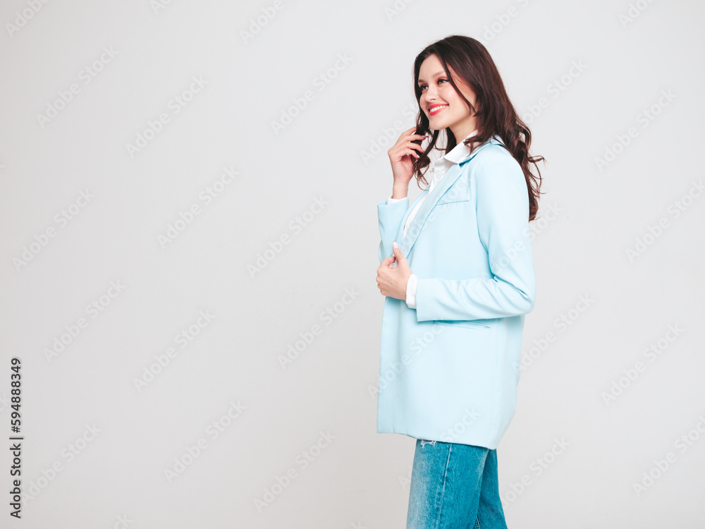 Portrait of young beautiful brunette woman wearing nice trendy blue suit jacket and jeans. Sexy fashion model posing in studio. Fashionable female isolated on white. Cheerful and happy Portrait of young beautiful brunette woman wearing nice trendy blue suit jacket and jeans. Sexy fashion model posing in studio. Fashionable female isolated on white. Cheerful and happy