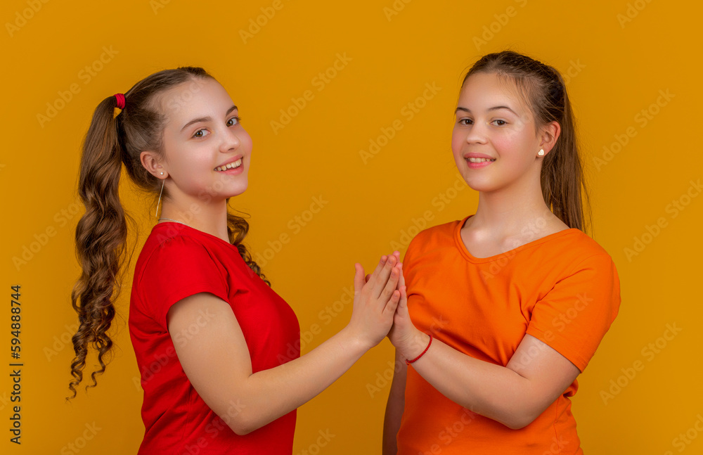 smiling children on yellow background. hello gesture