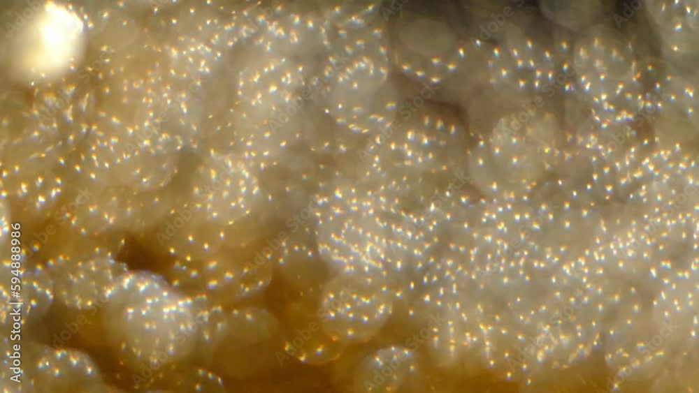 Golden glitter defocused background in slow motion. Beautiful transition with real gold particles. flying in wind on black background, shot with depth of field. Golden glitter defocused background in slow motion. Beautiful transition with real gold particles. flying in wind on black background, shot with depth of field.