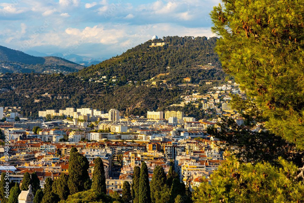 Nice sunset panorama with Riquier, Cimiez and Saint Roch historic old town districts with Alpes mountains at French Riviera of Mediterranean Sea in France